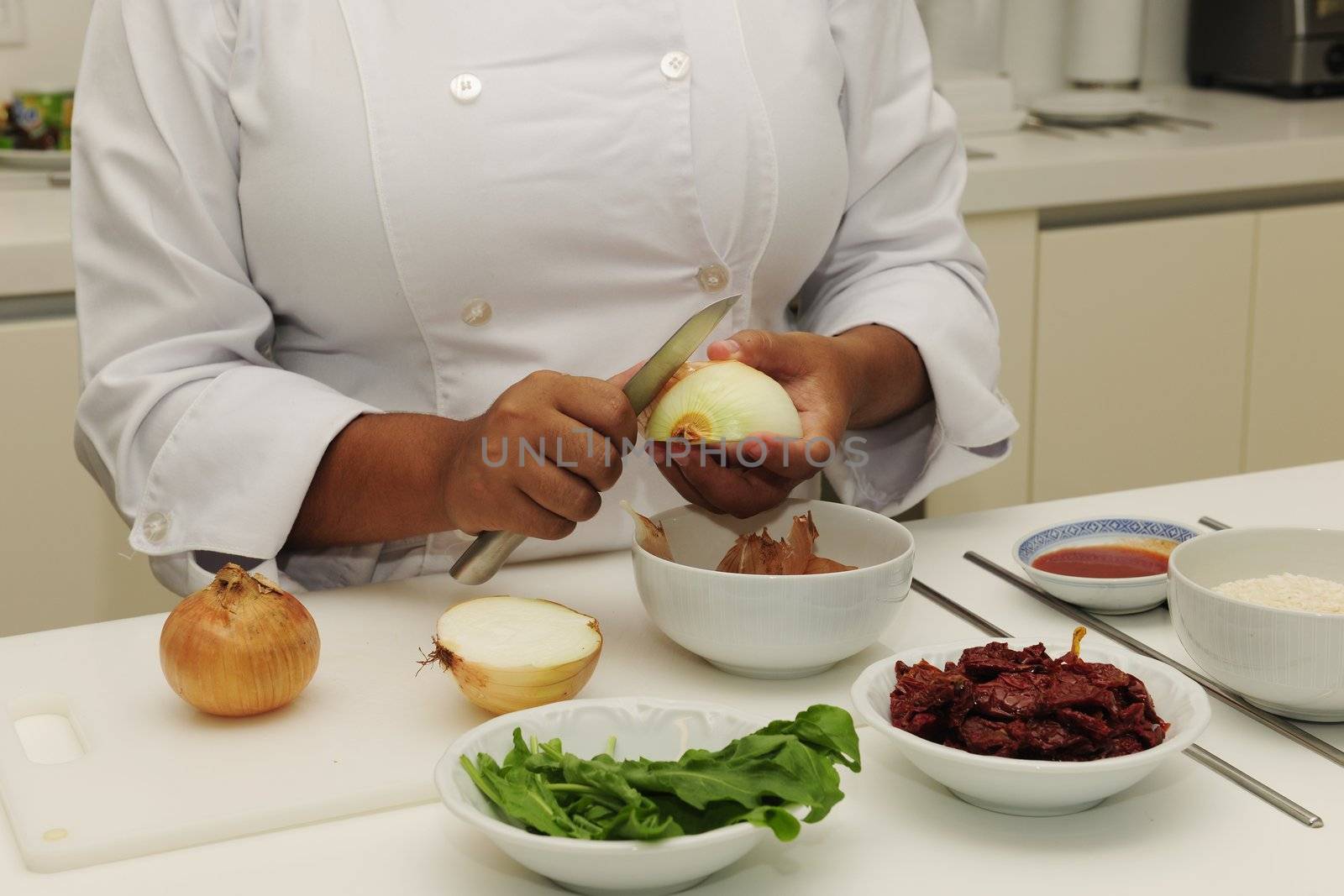 Happy chef cutting onions in a modern kitchen