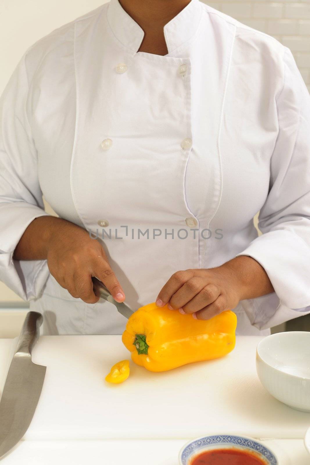 Professional chef cutting yellow pepper