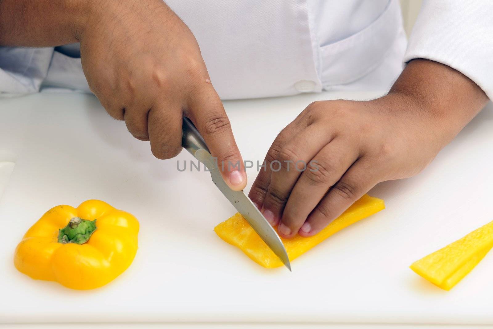 Professional chef cutting yellow pepper