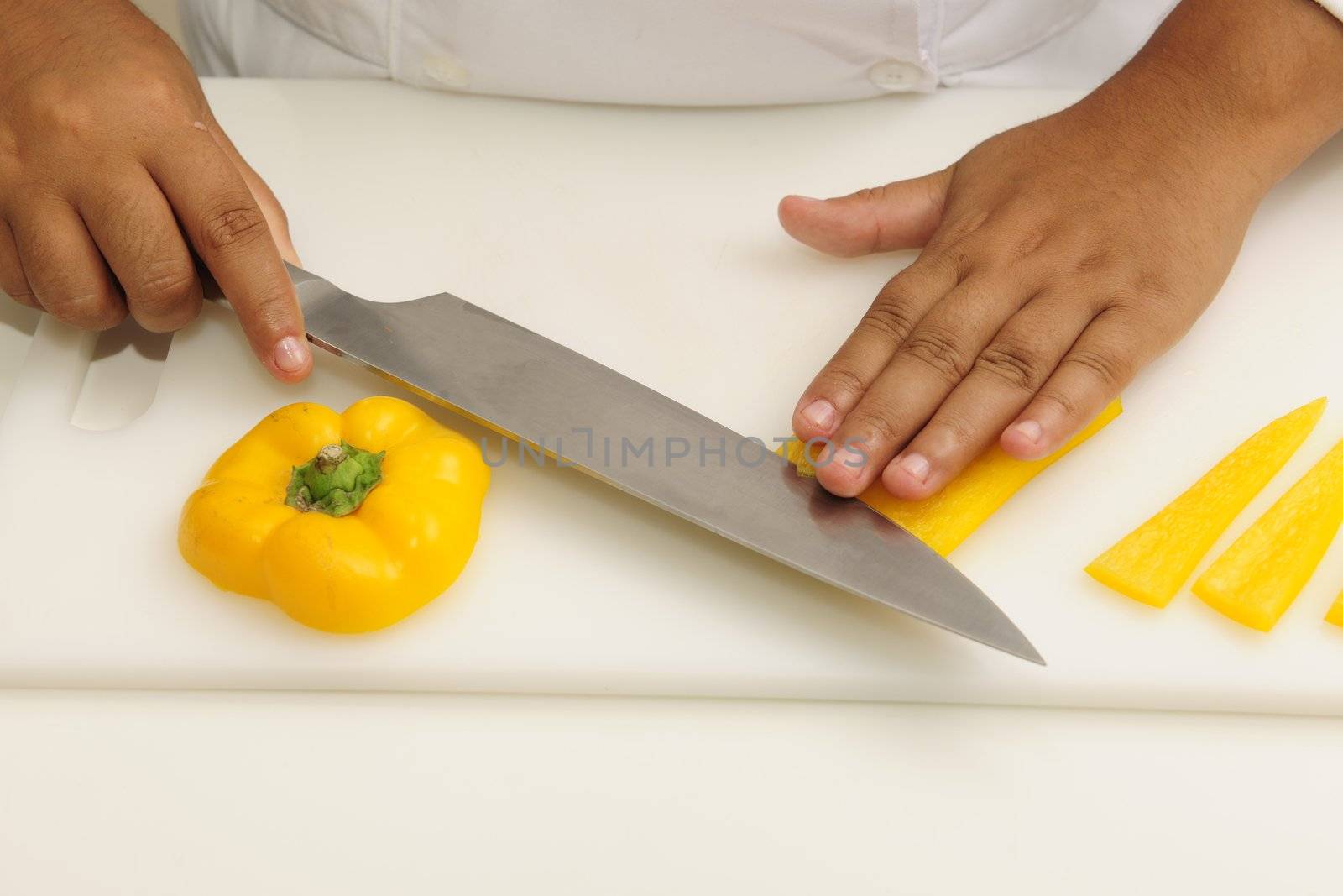 Professional chef cutting yellow pepper
