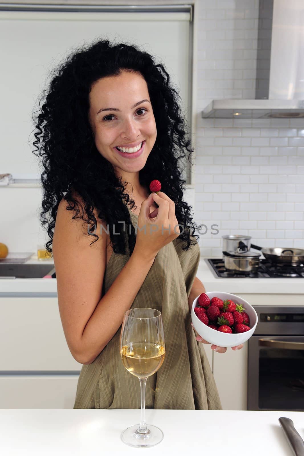 Woman eating strawberries and drinking wine
