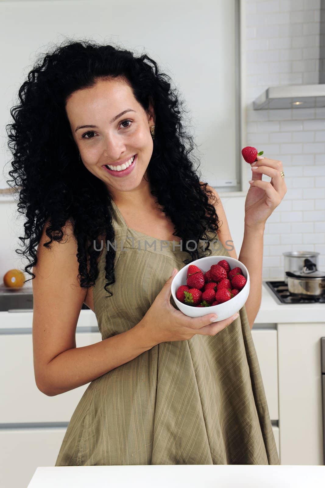 Woman eating strawberries in a modern kitchen