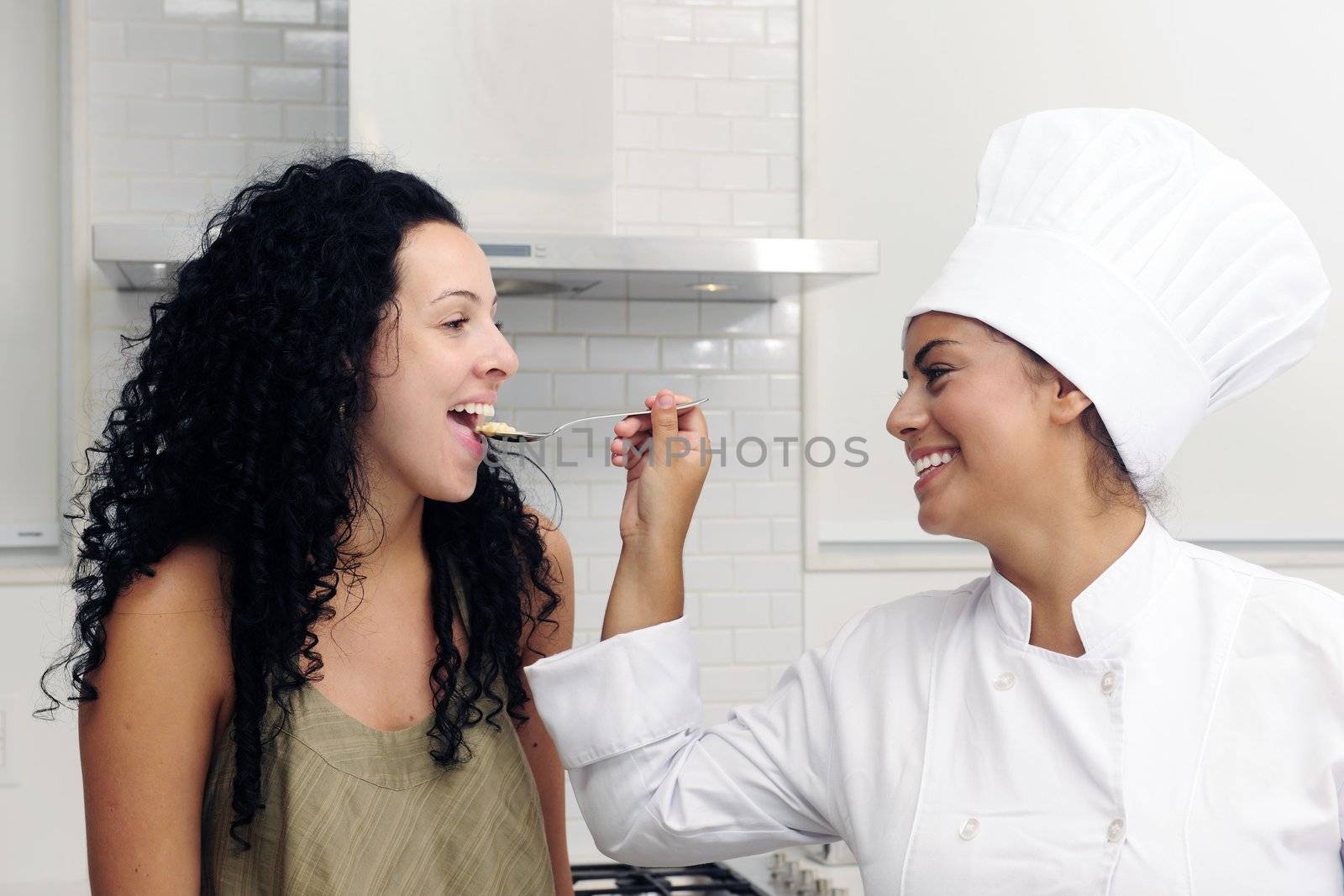 Cookery course: Chef offering his tasty risotto on a spoon for tasting