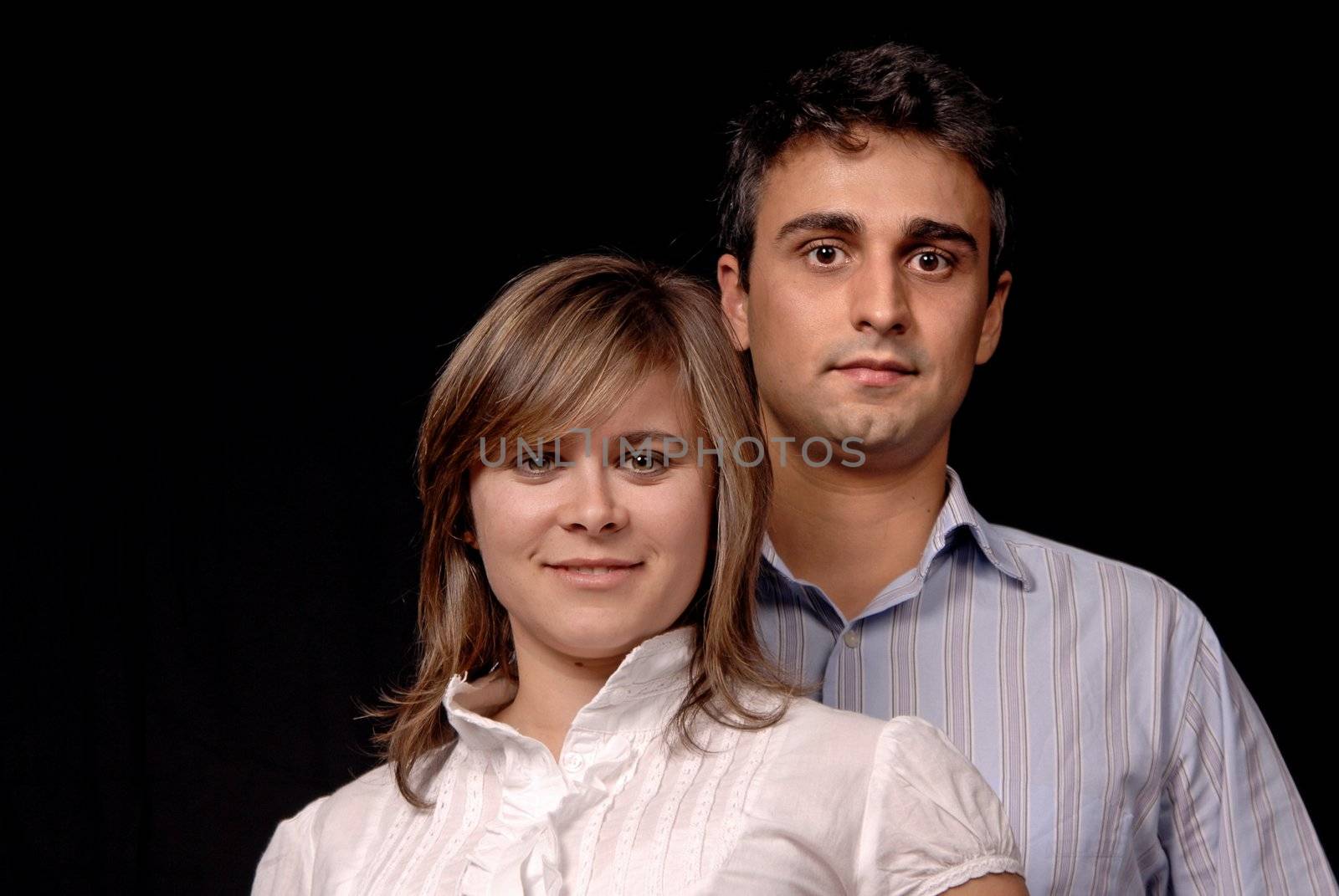 young couple together portrait on black background