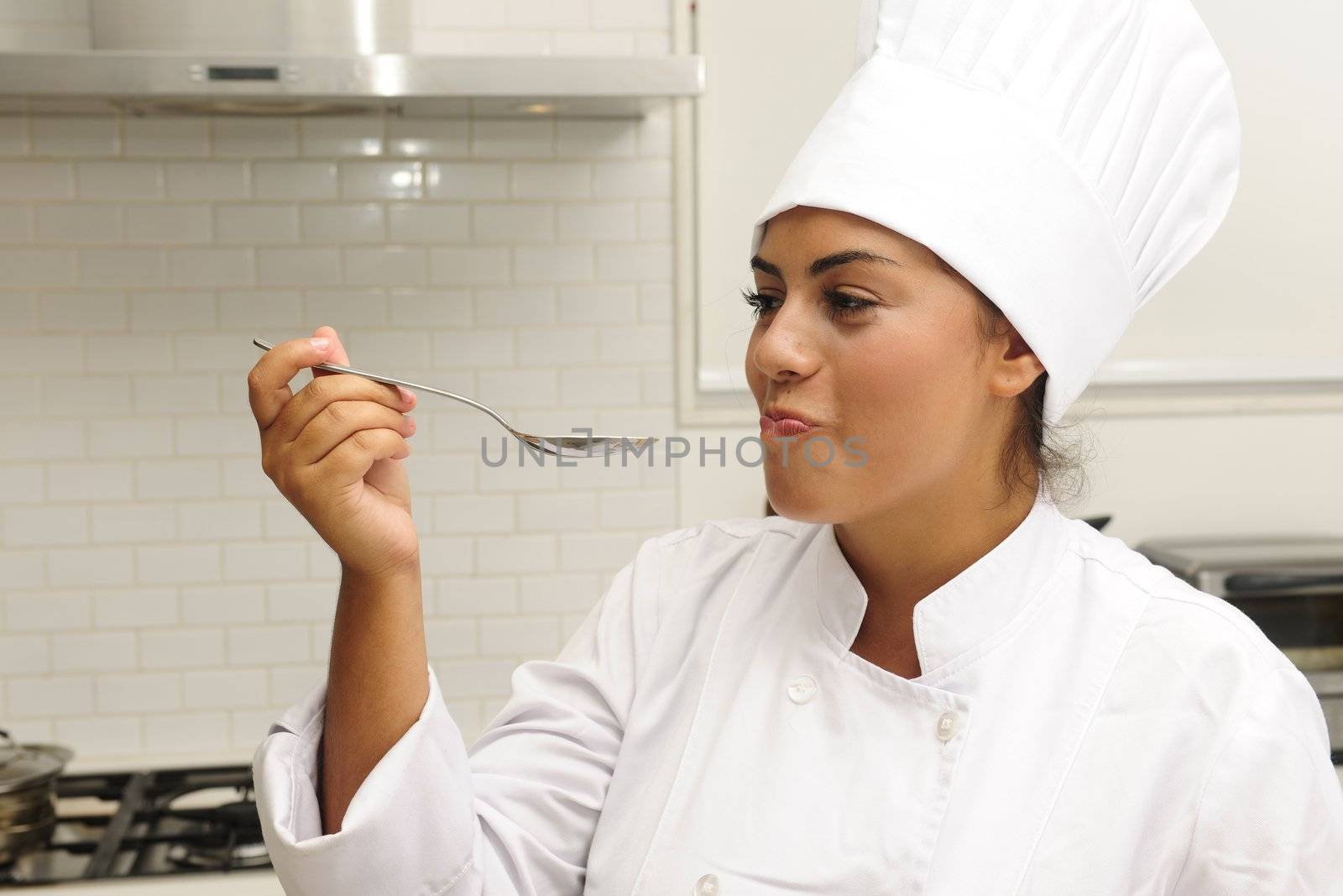 Chef cooking risotto having a taste