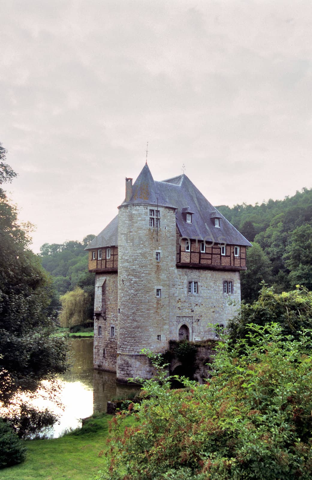 The sun sets on a castle surrounded by a moat in the Wallonian region of Belgium.