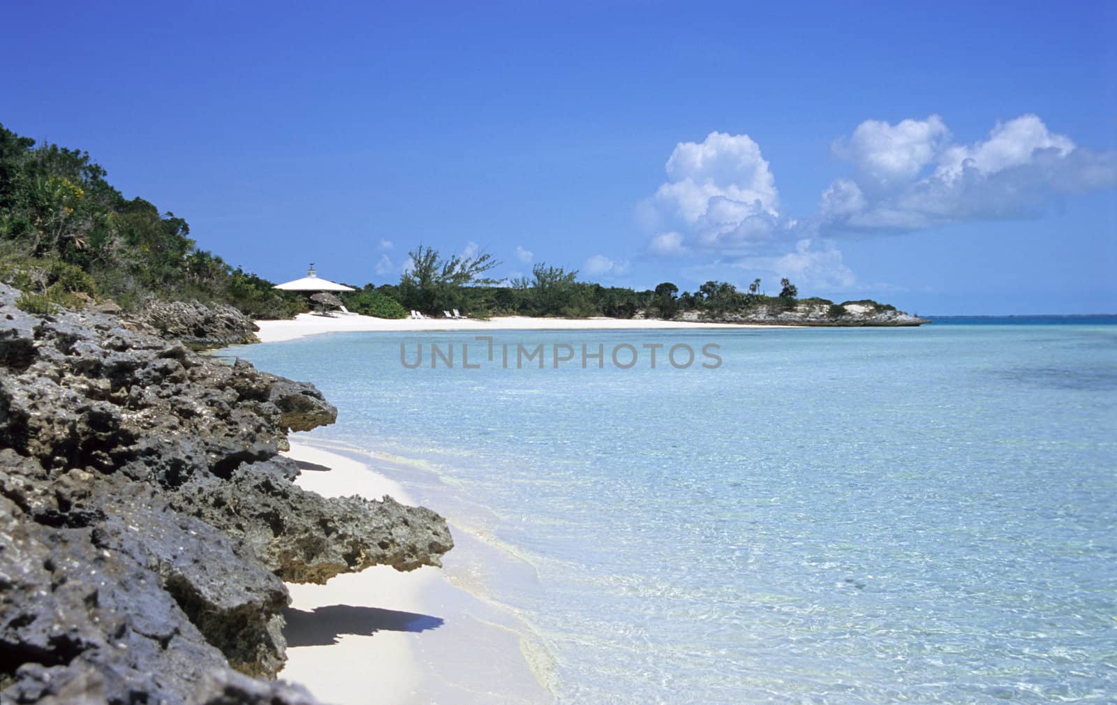 The white sandy beaches and volcanic rock of a deserted island in the Bahamas.