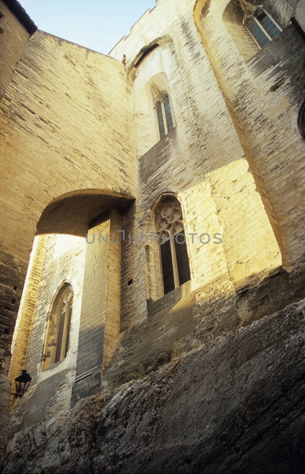 Ached windows and corridors of the massive stone Papal Palace in Avignon, France.