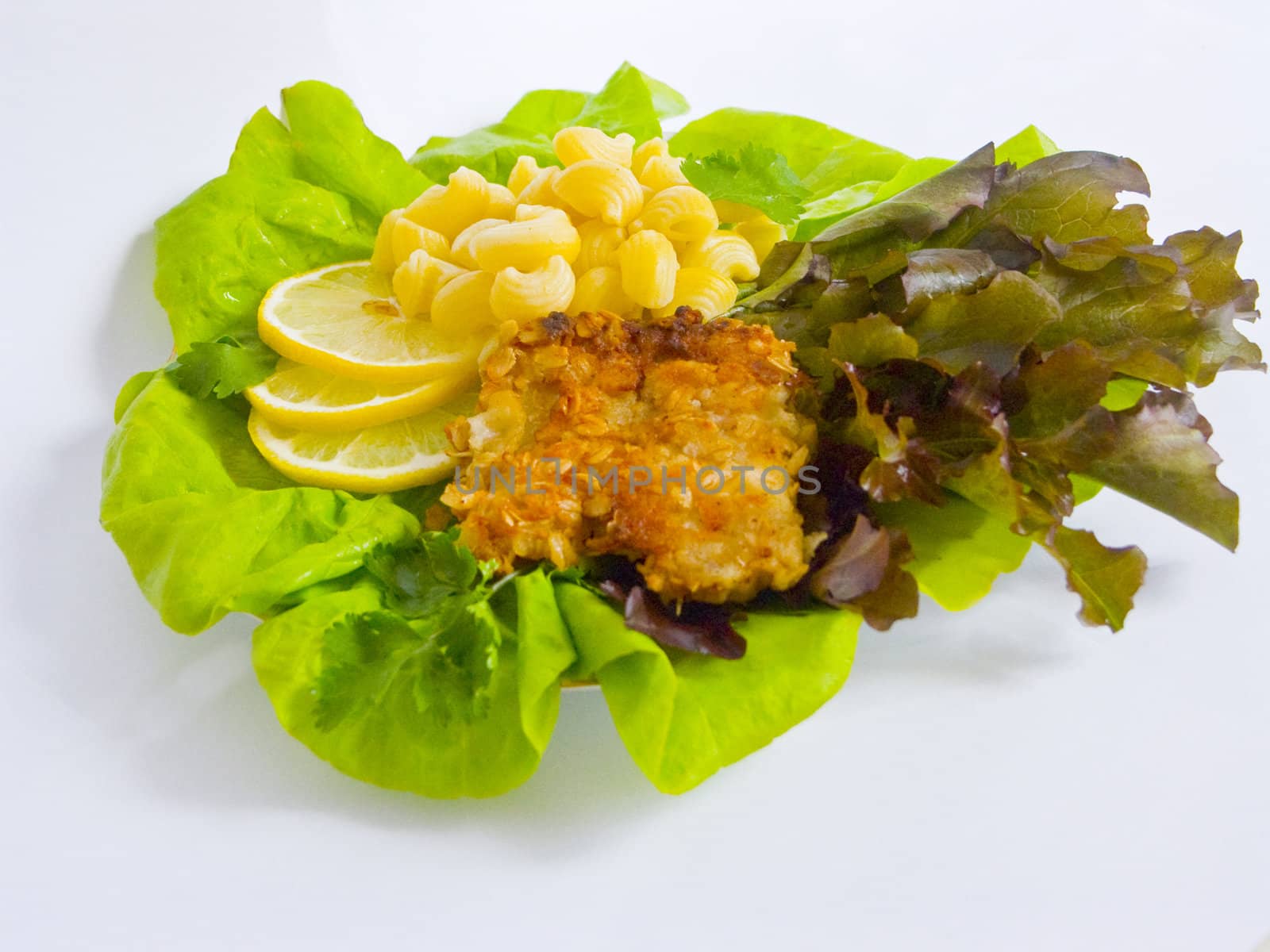 The image of macaroni of a fish and slices of a lemon close up