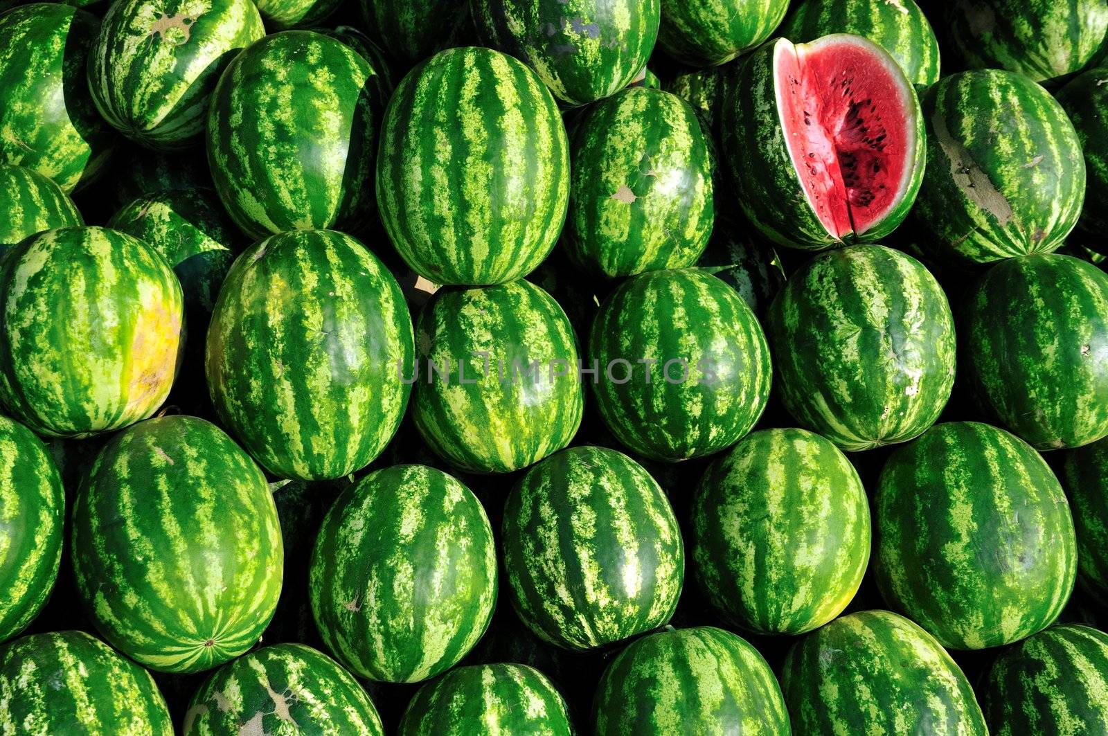 background of pile of fresh watermelon stacked and ready to sell. 