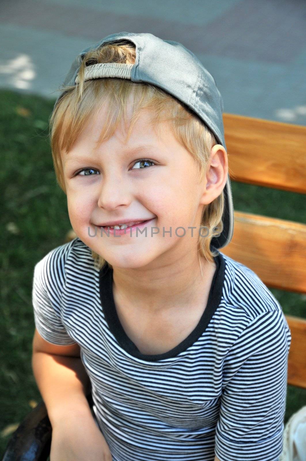 Happy young boy sitting on the bench