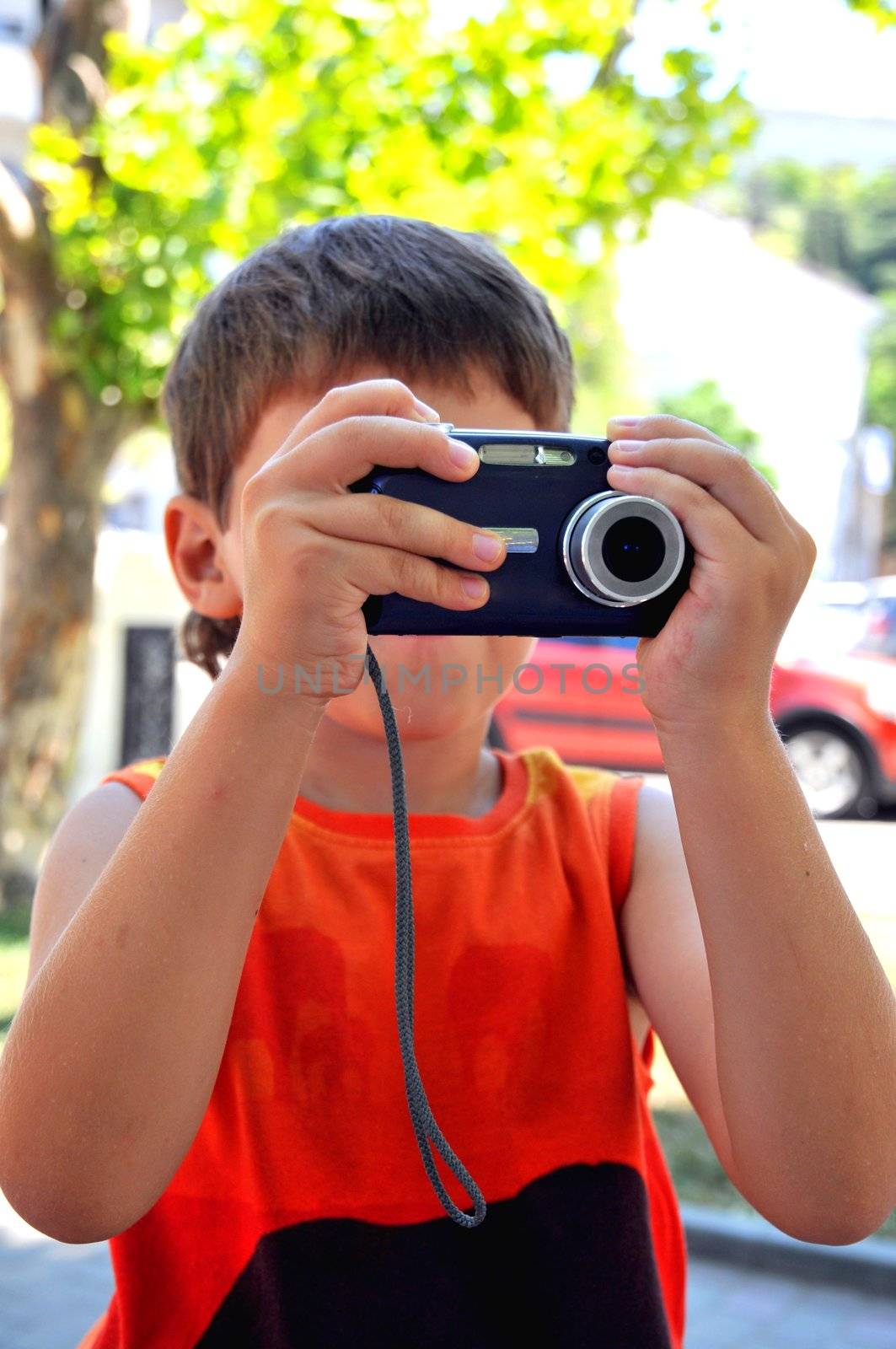 Little boy holding digital camera, he taking photo