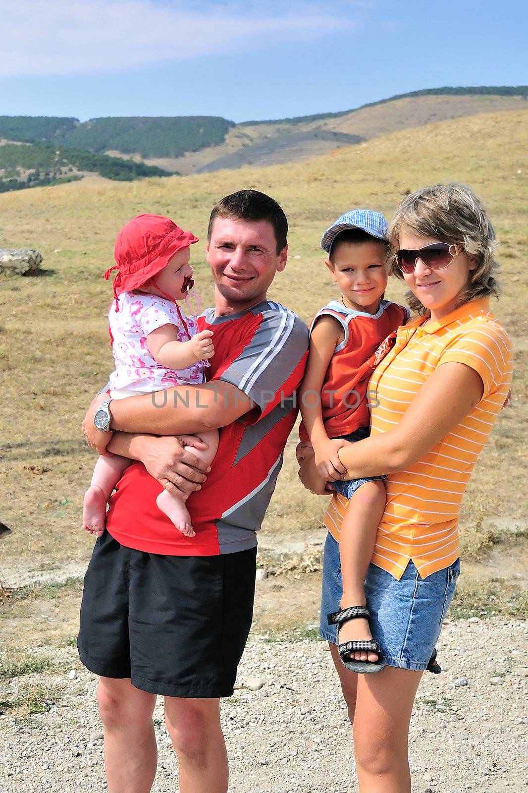 mother, father, son and daughter are outdoors, they are happy