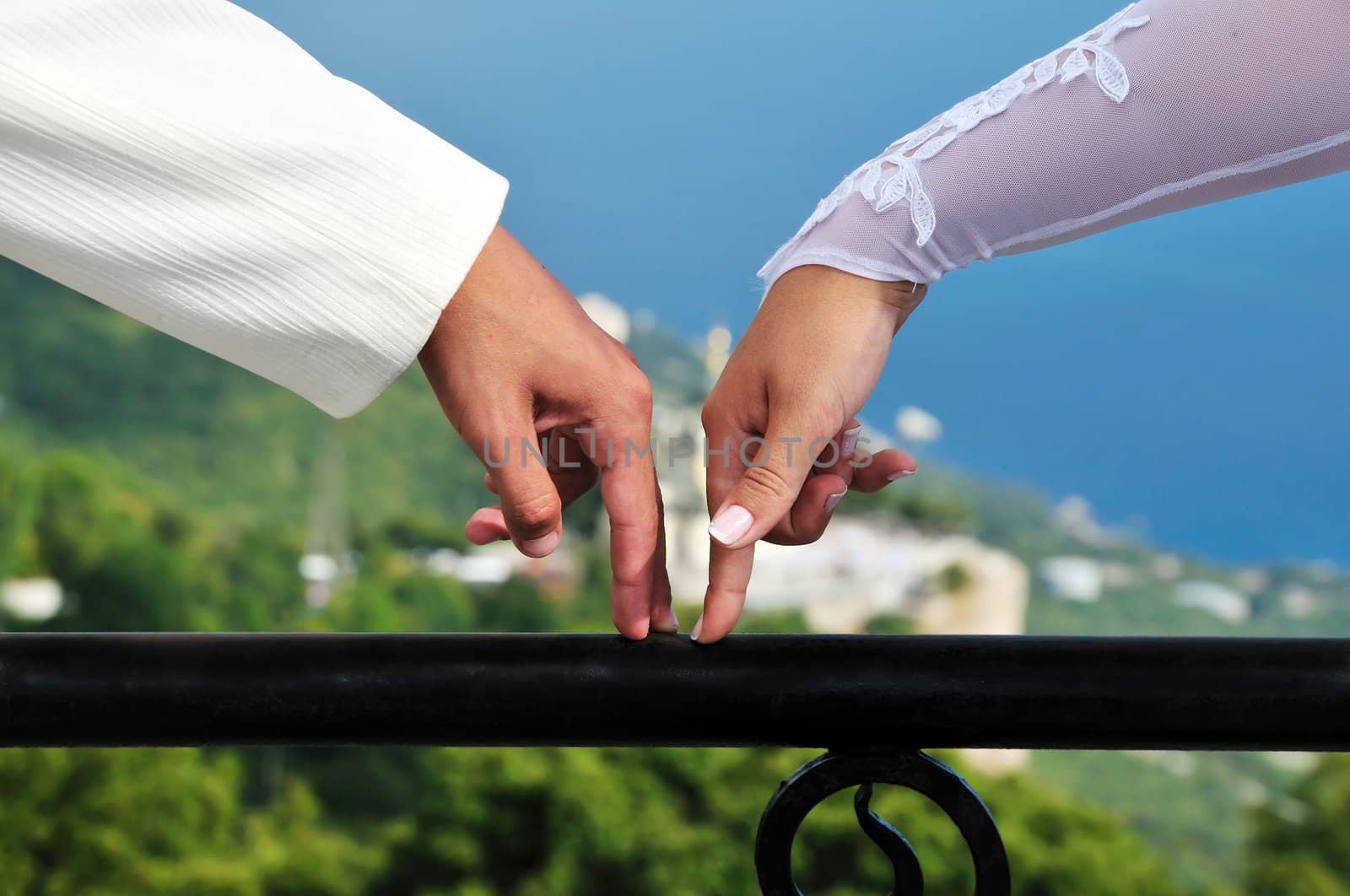 fingers of bride and groom going towards each other over wonderful view