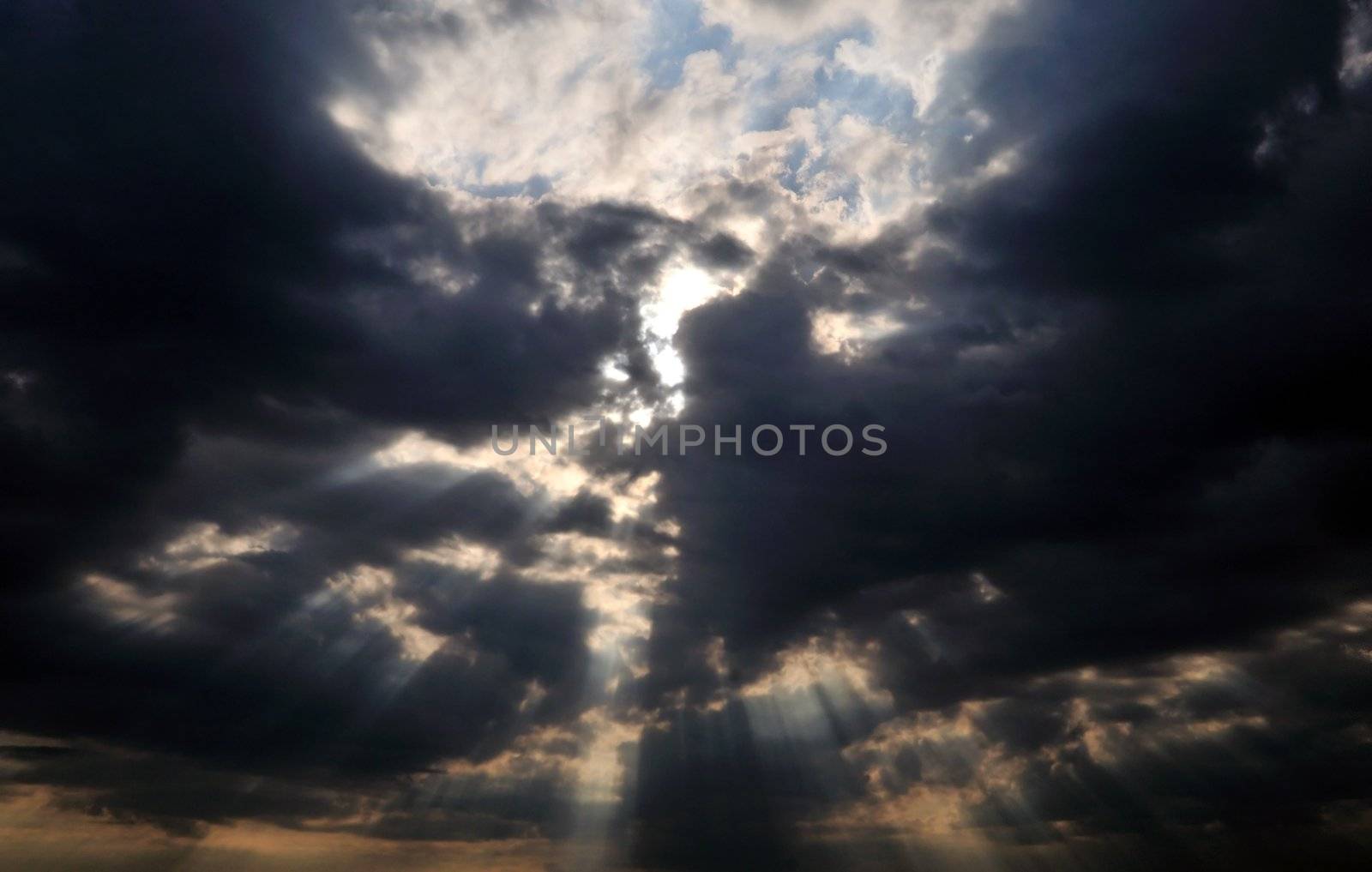 dark clouds and little peace of blue sky with sunlight