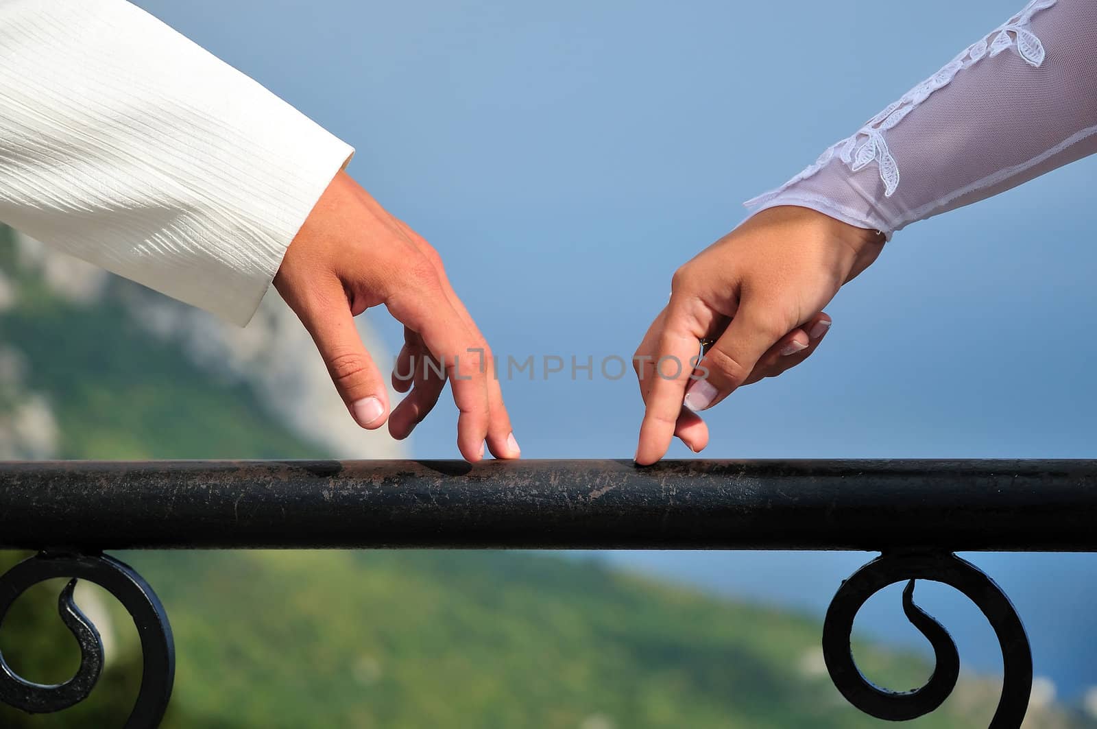 fingers of bride and groom going towards each other over wonderful view