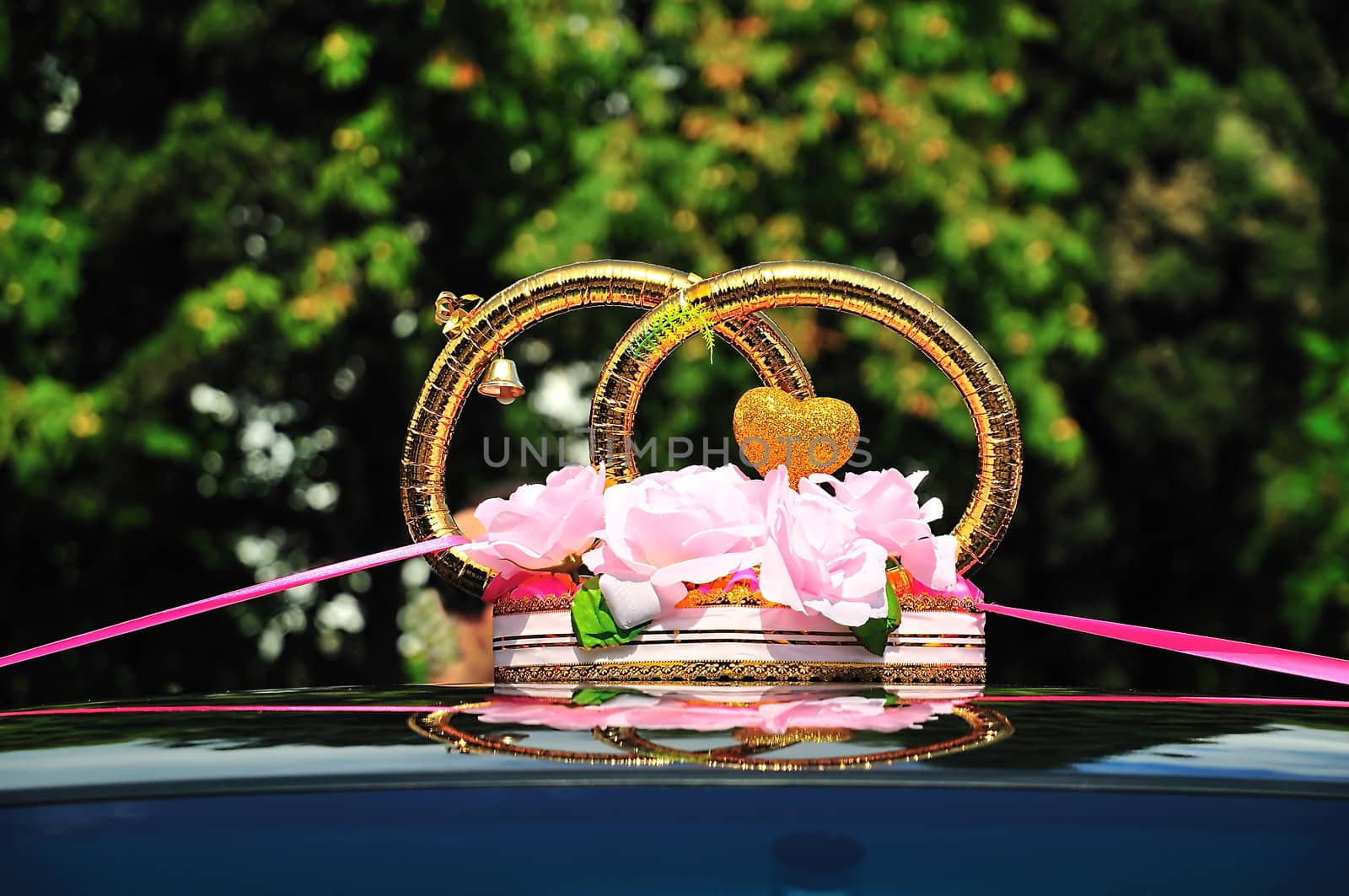 gold rings, heart and roses on the top of wedding car