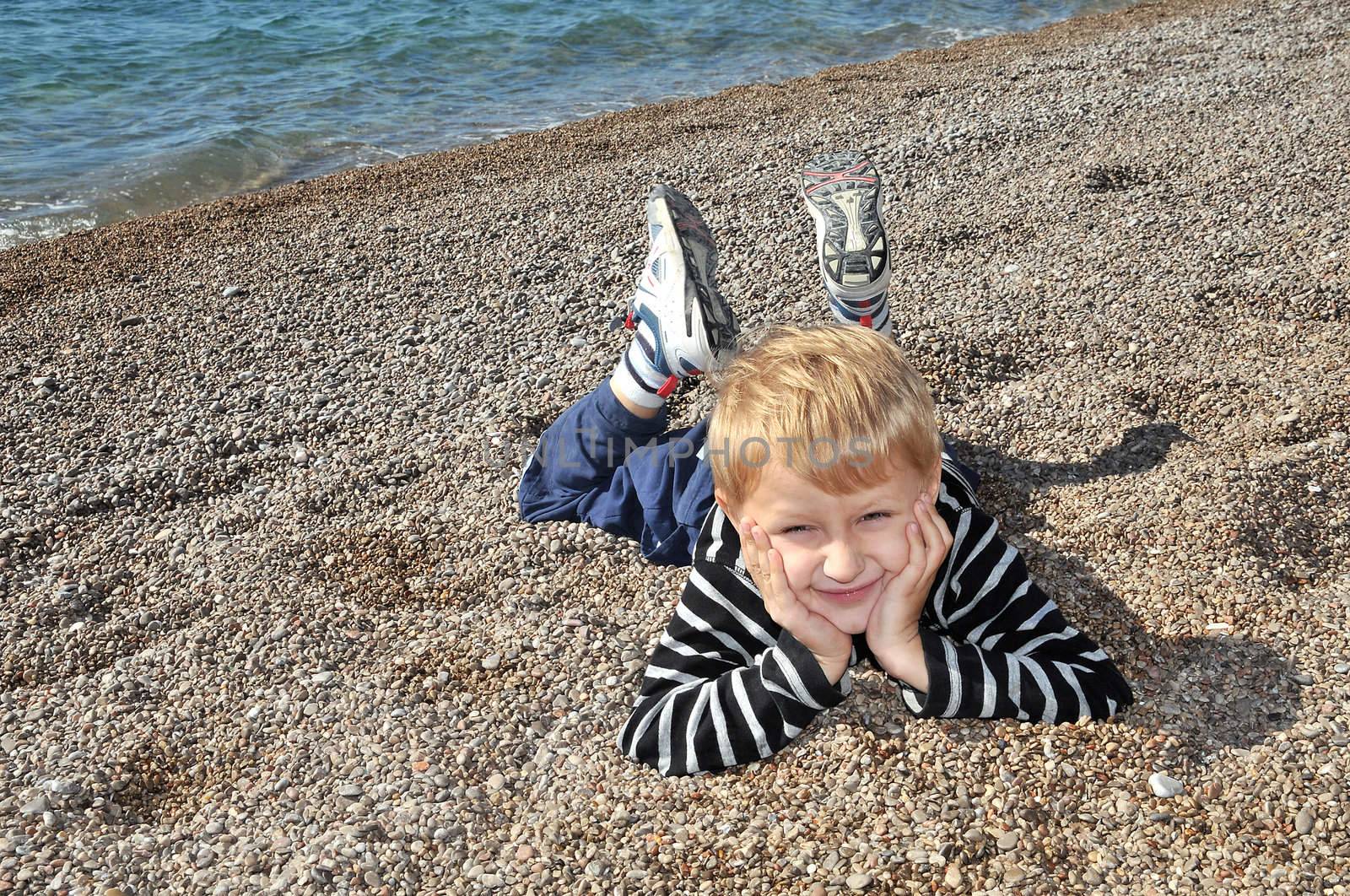 boy is laying at the beach in autumn time