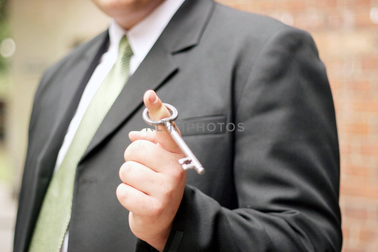 man proudly holding a key to serious real estate