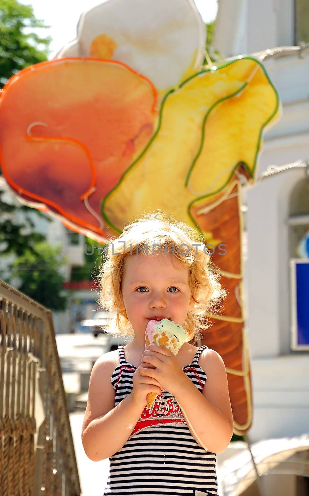 little girl outdoors eating huge ice cream cone