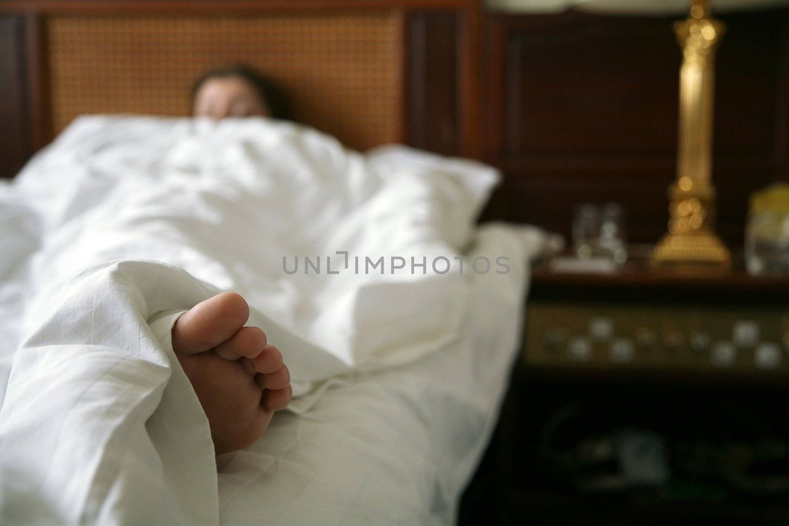 sleeping in a hotel room, selective focus on bare foot