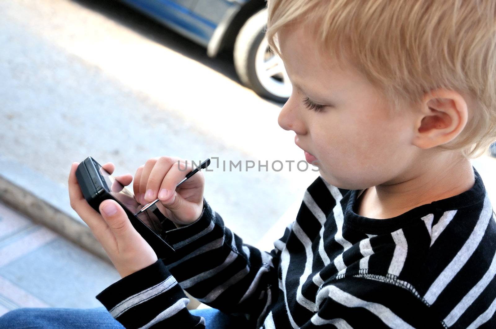little boy using smartphone with stylus