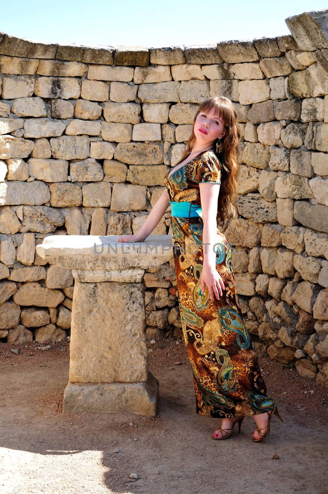 longhaired beautiful girl standing close to Classical Greek's  altar