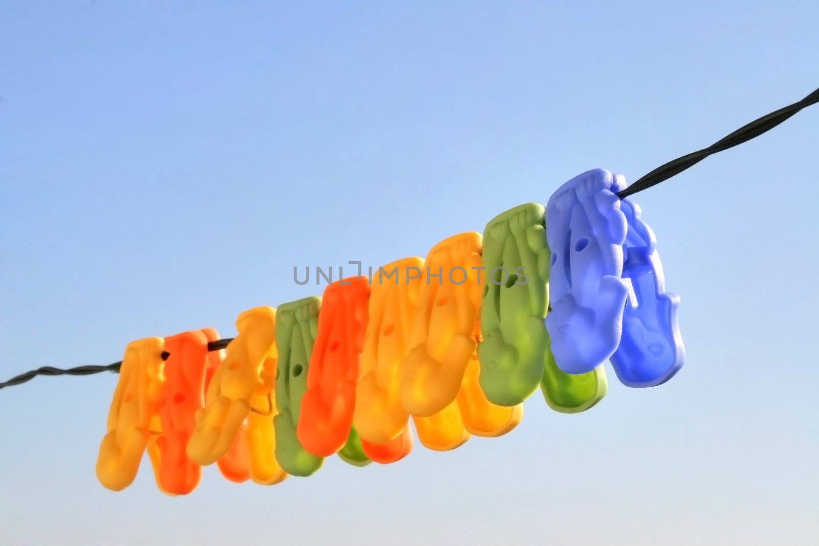 colorful clothes pins hanging in line on a blue sky