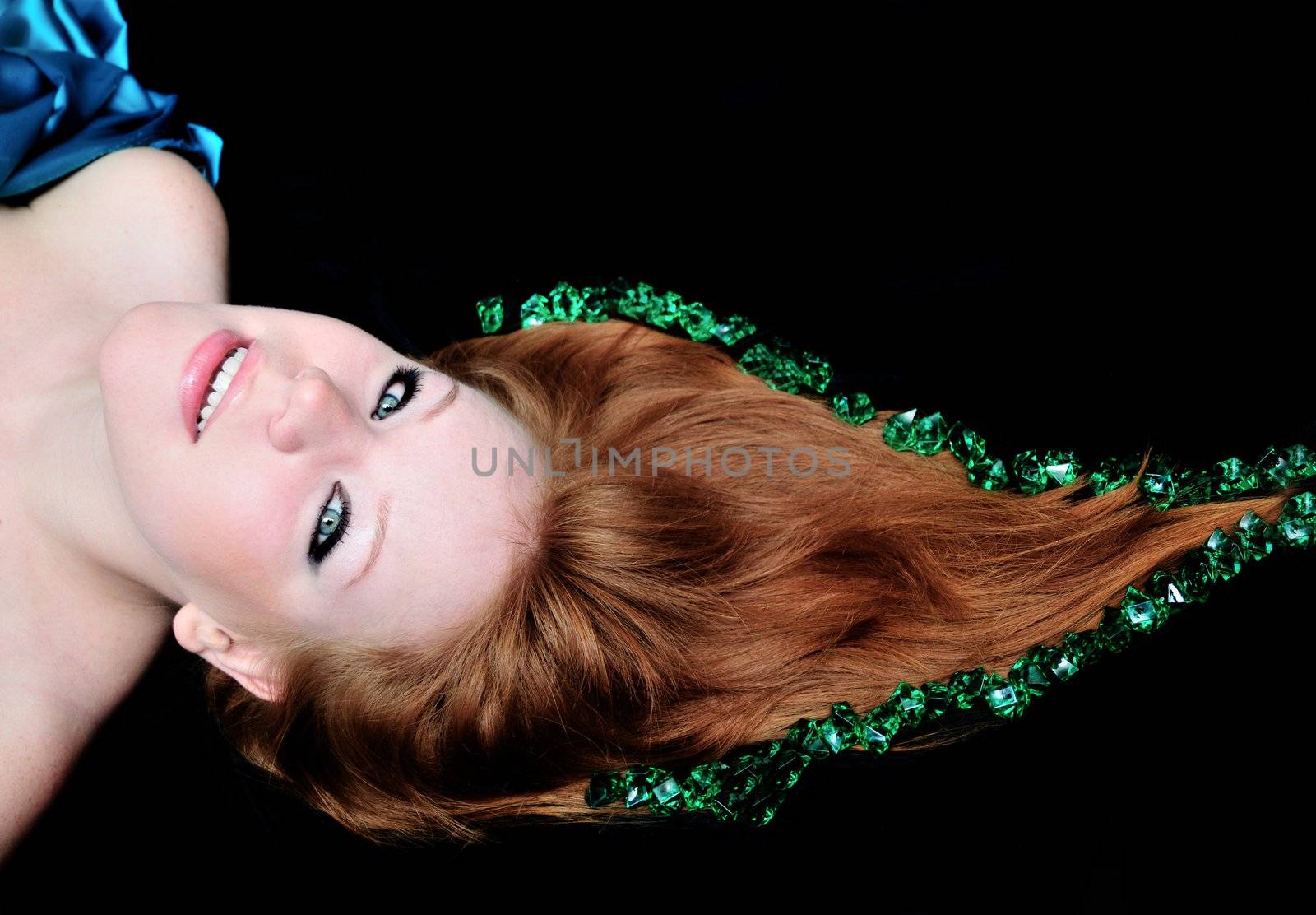 head of girl with natural red hair over black.