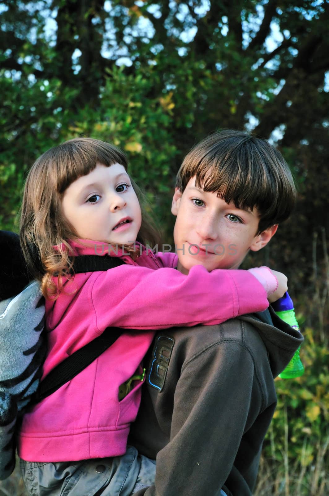 Brother carrying his little sister on  the outdoor
