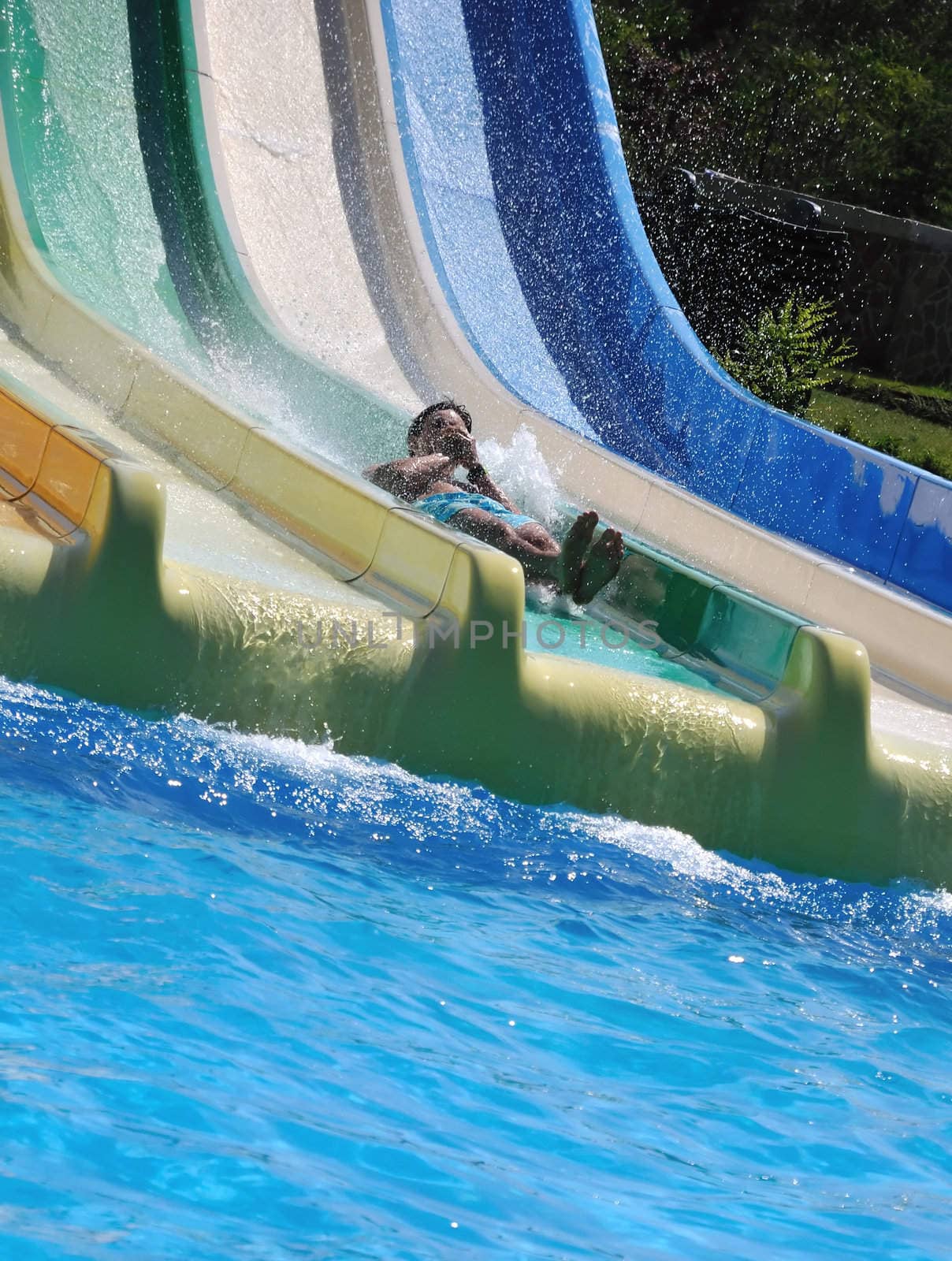 outdoor water park , man is driving down rapid descent