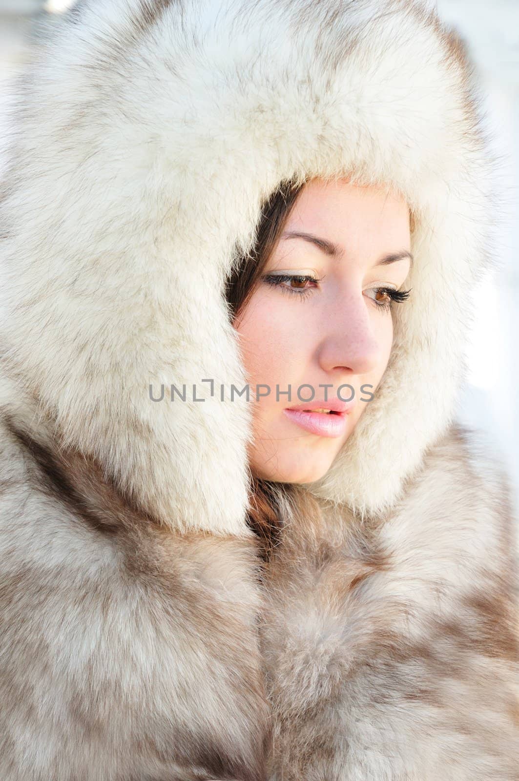 Pretty brunette with hazel eyes is wearing winter fur cap 