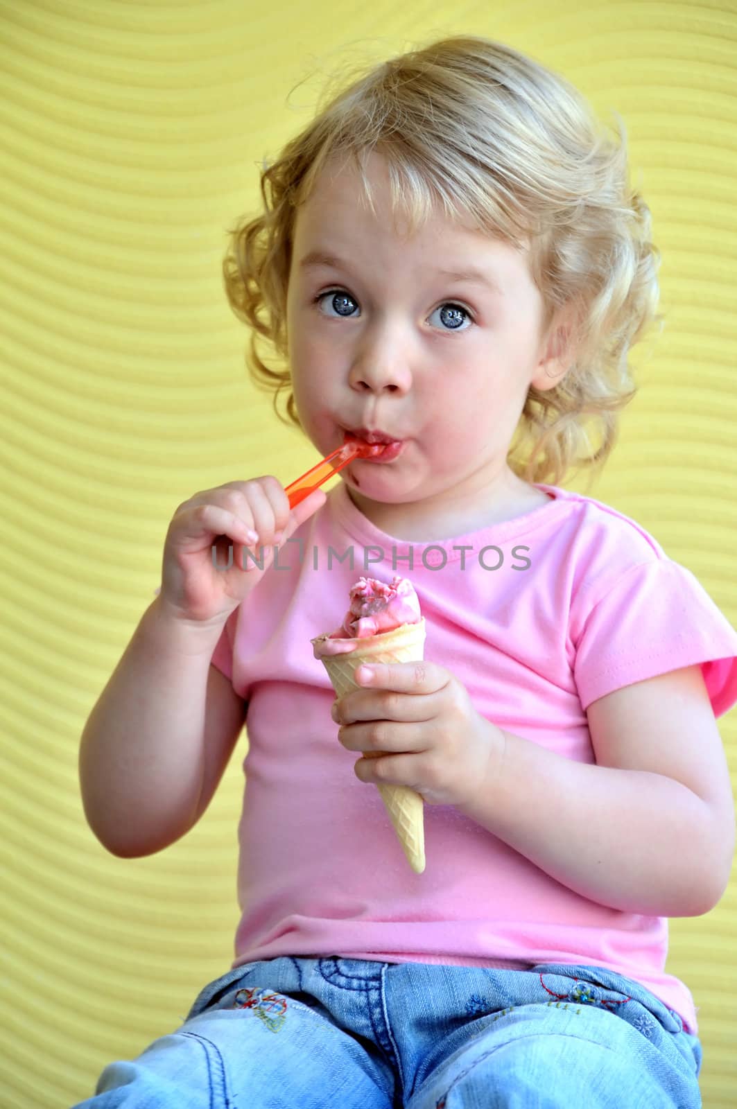 little girl outdoors eating huge ice cream cone
