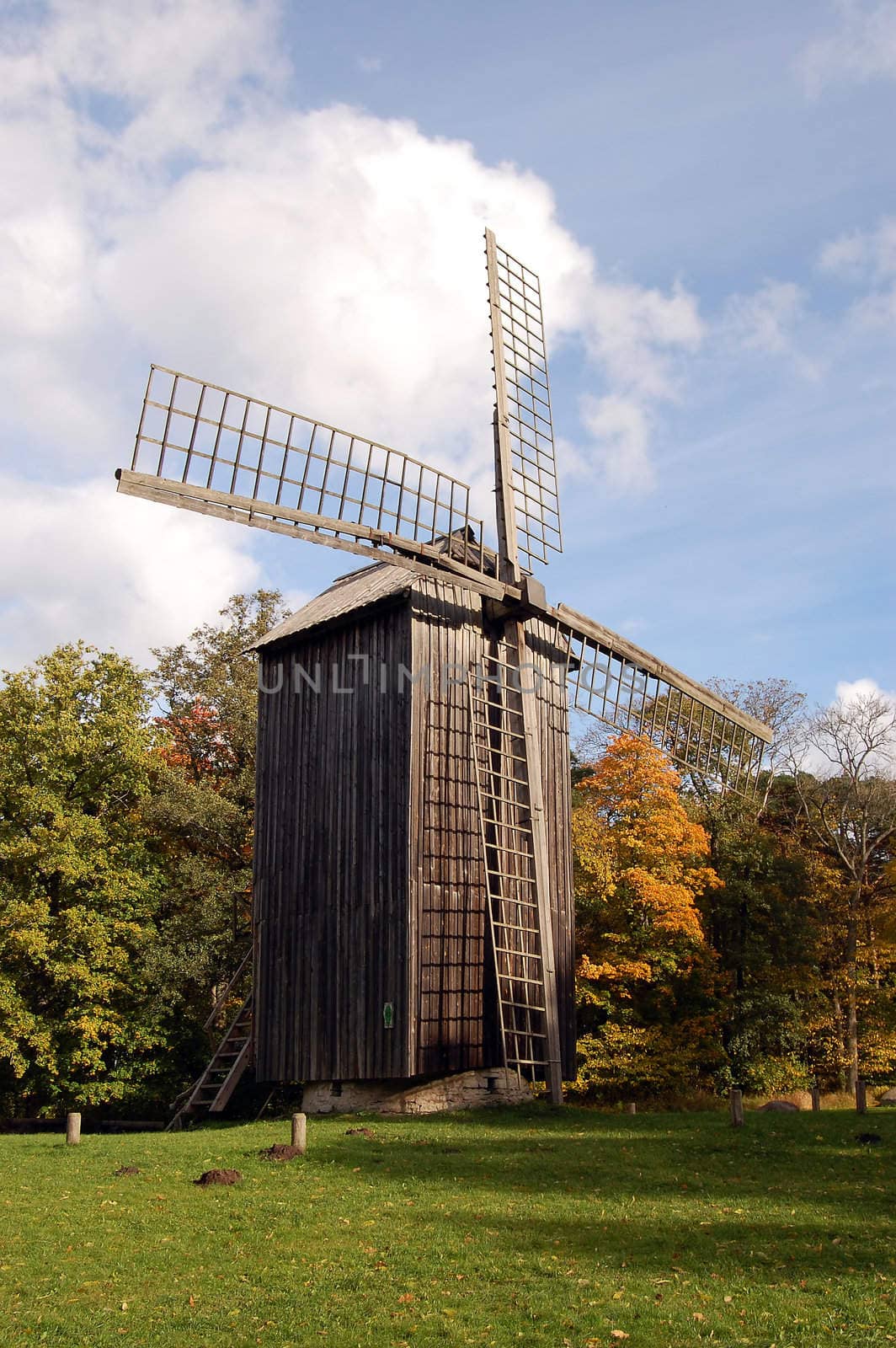 Old windmill in the front of autumn trees