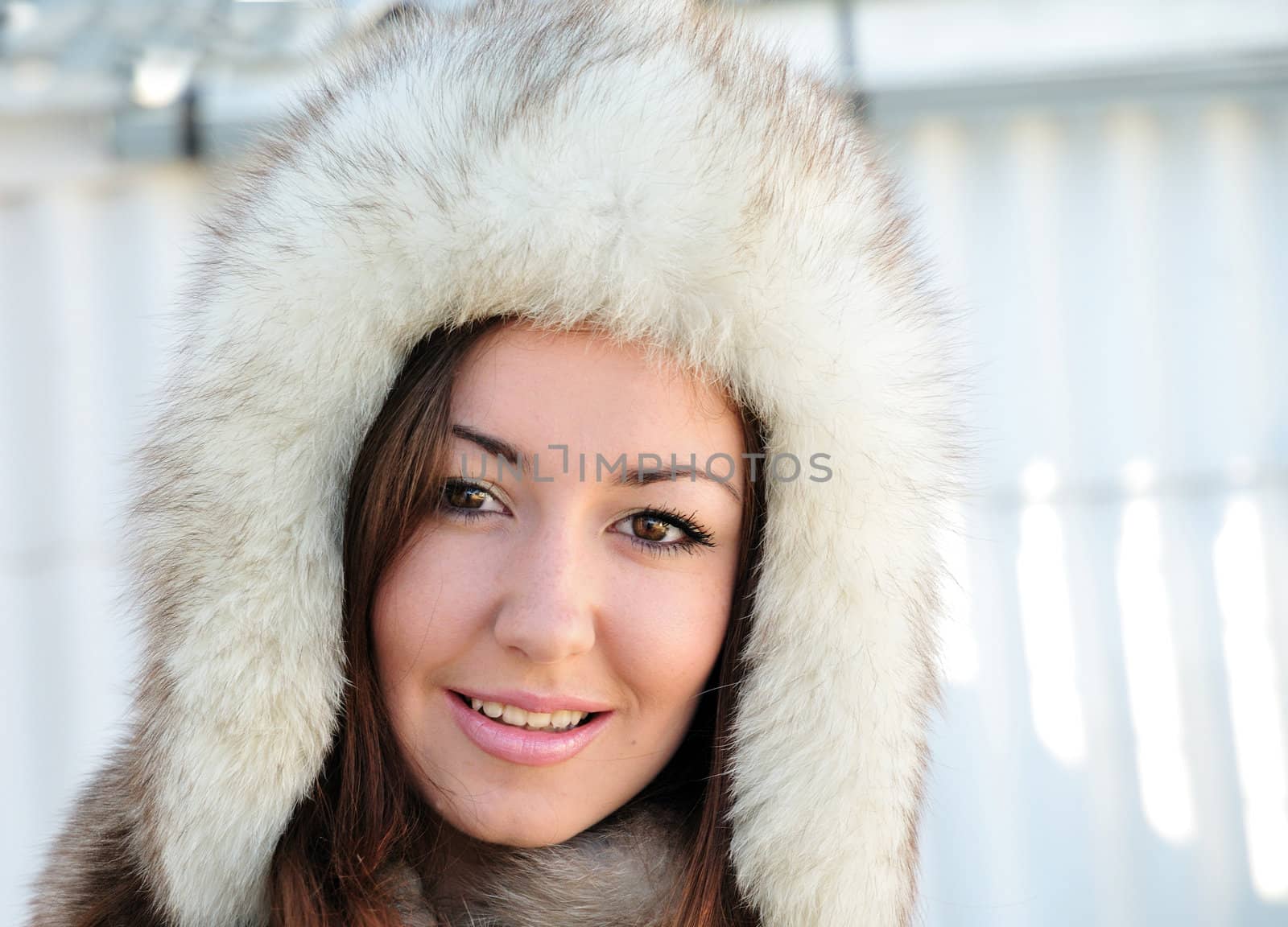 Pretty brunette with hazel eyes is wearing winter fur cap 