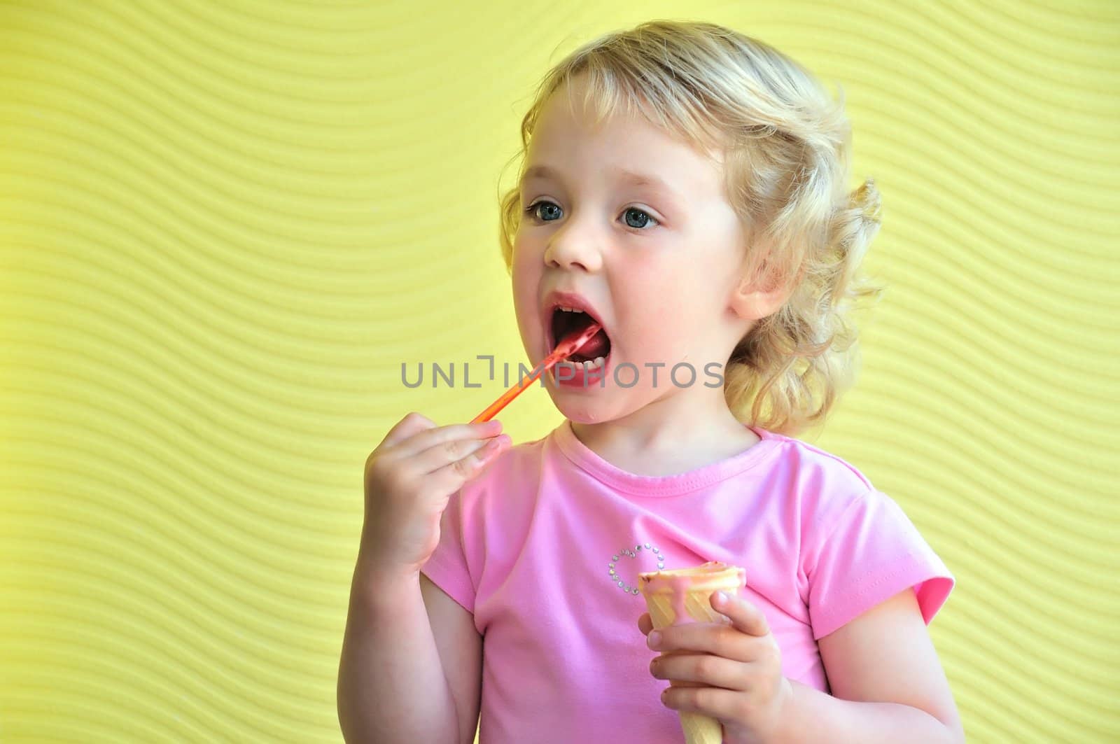 little girl outdoors eating huge ice cream cone

