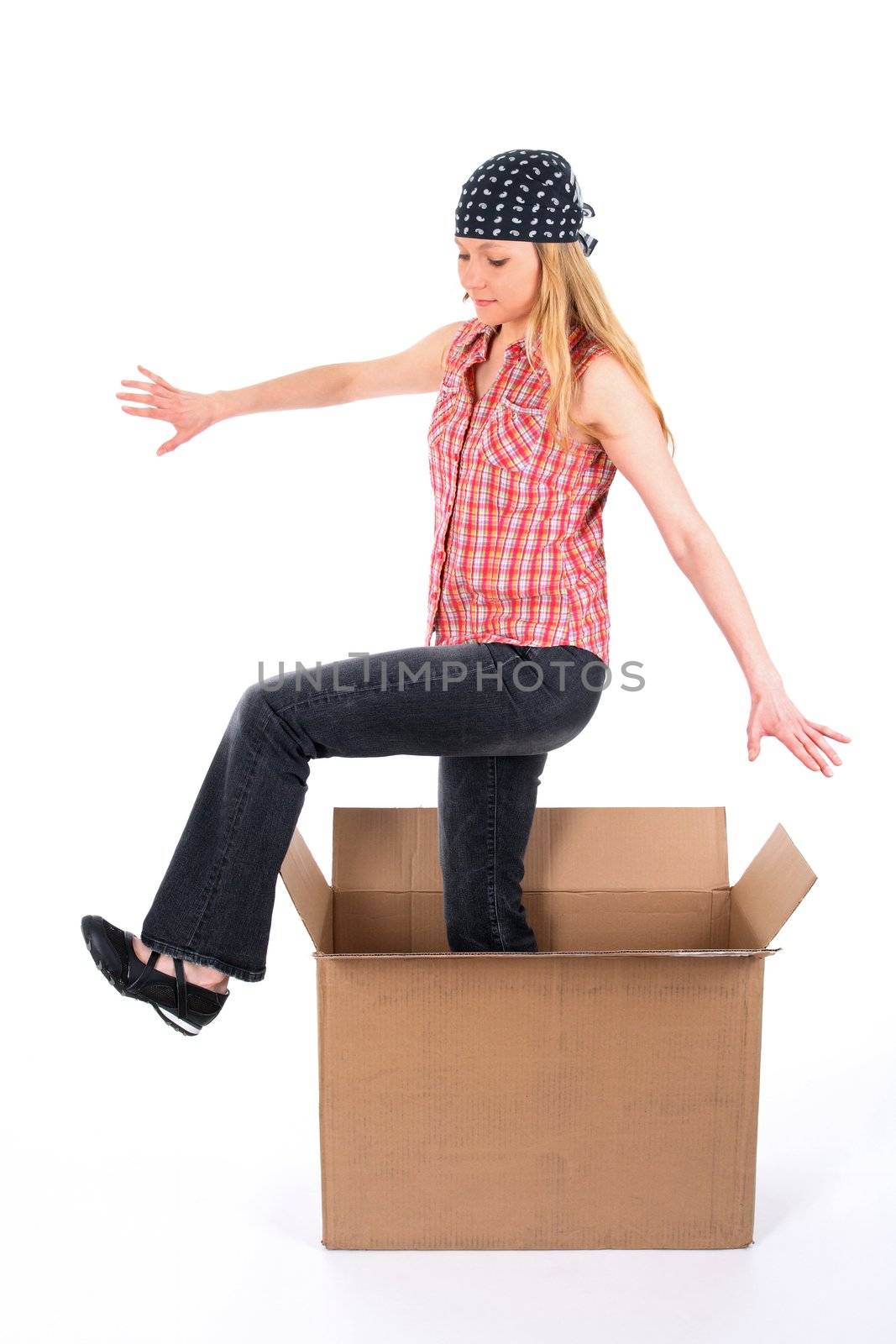 Girl wearing bandanna steps out of a cardboard box.