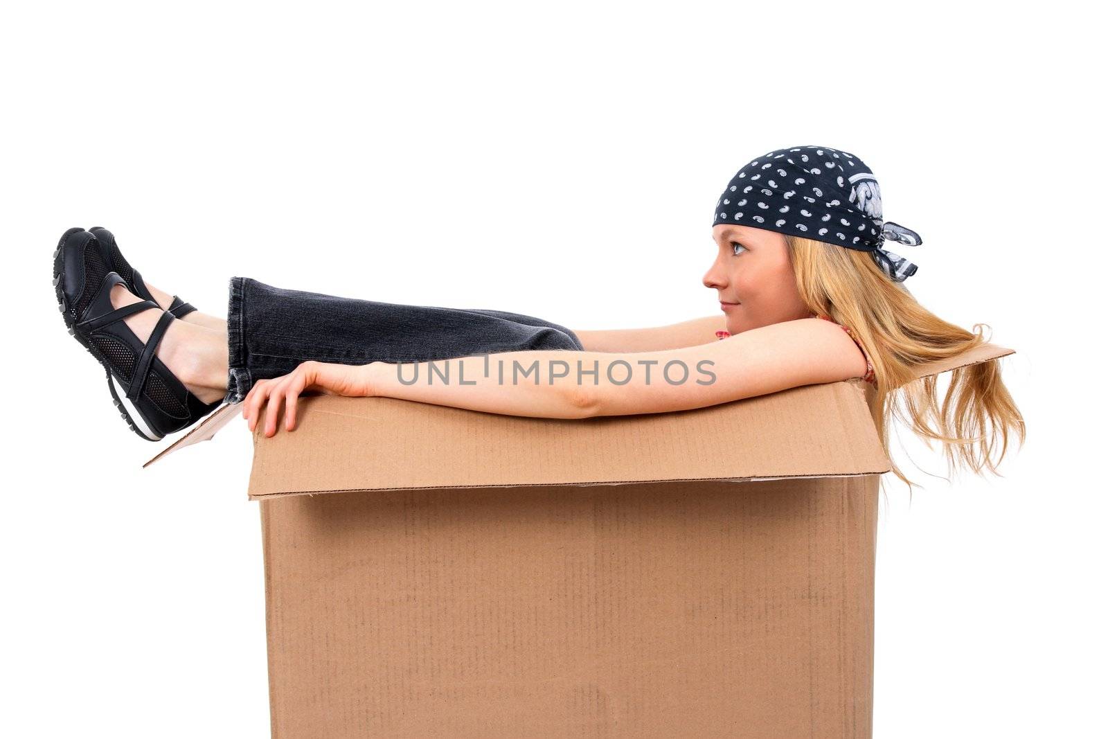 Girl sitting in a cardboard box, copy space, isolated on white.