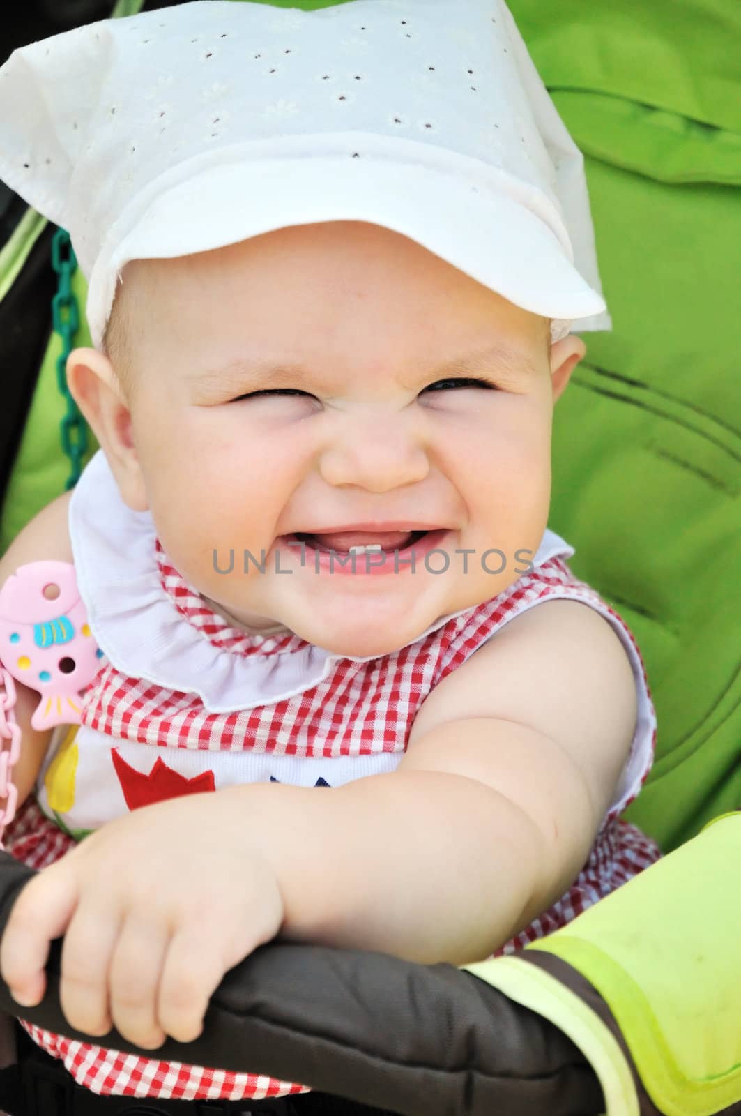 smiling baby girl sitting in the stroller