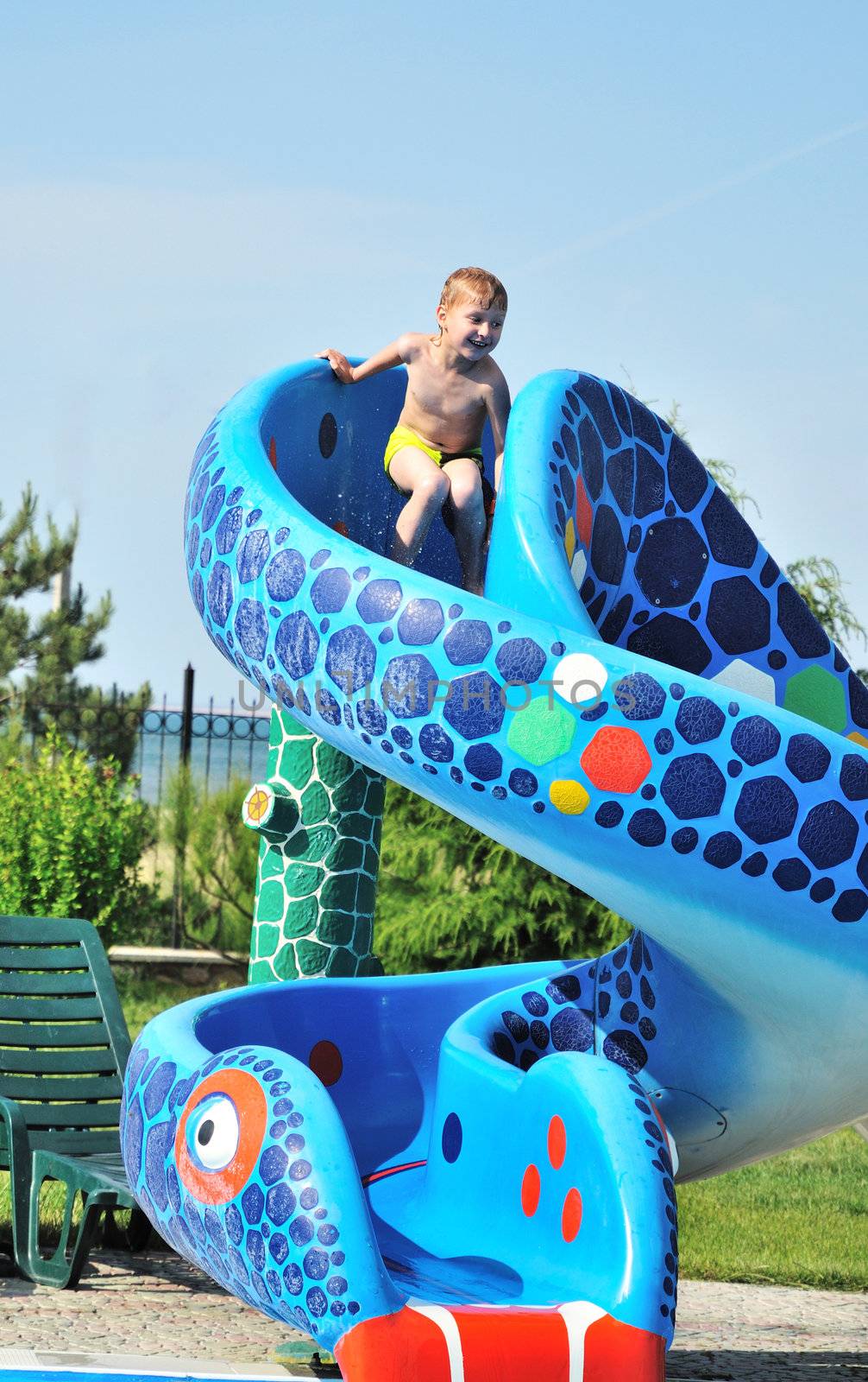 Cute little boy sliding down a water slide
