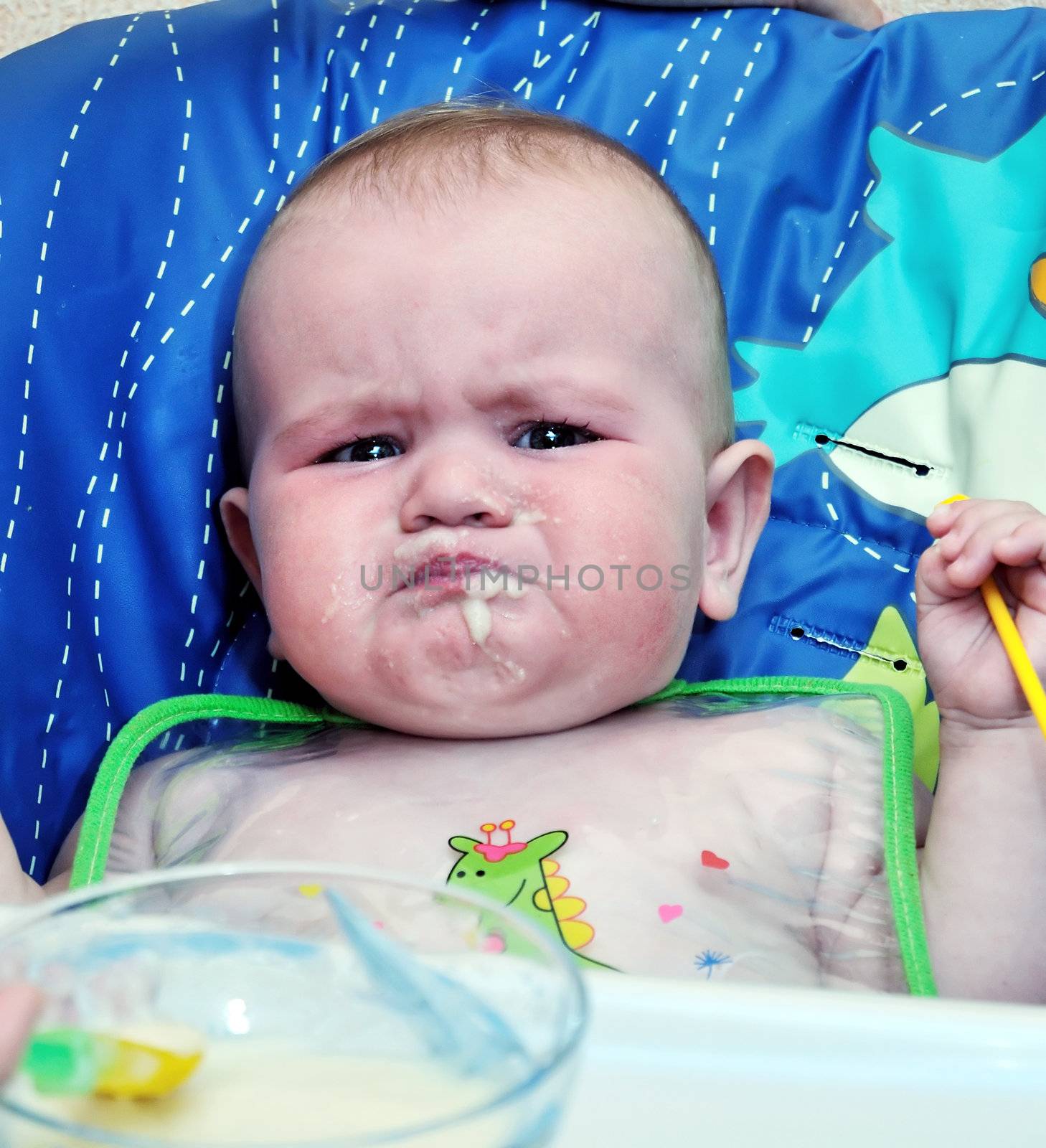 sad baby with full mouth of food, but it is not enough for her