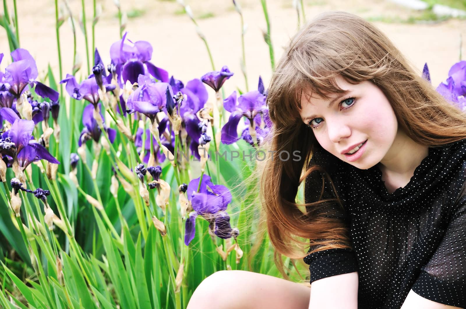 beautiful fashion model sitting next to the flowers