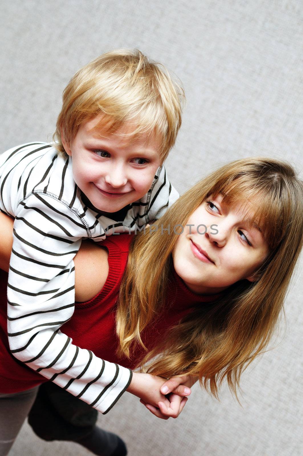 Brother and sister at home smiling and embracing

