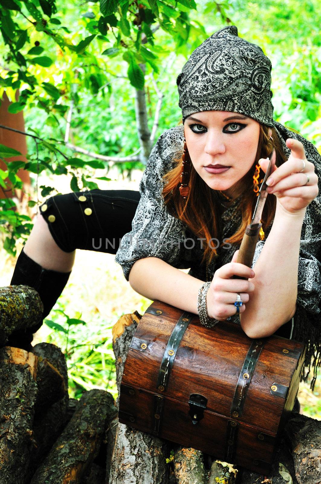 beautiful redheaded pirate girl is touching knife
