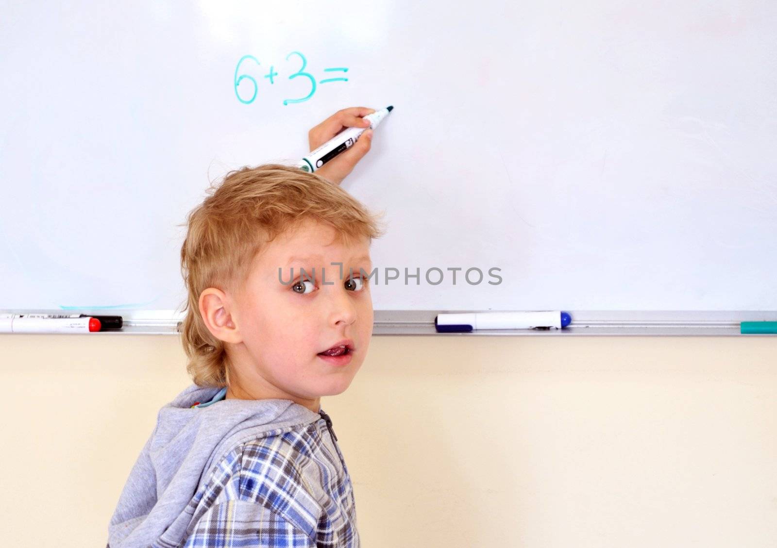  left-hander little boy solving exercise on desk 