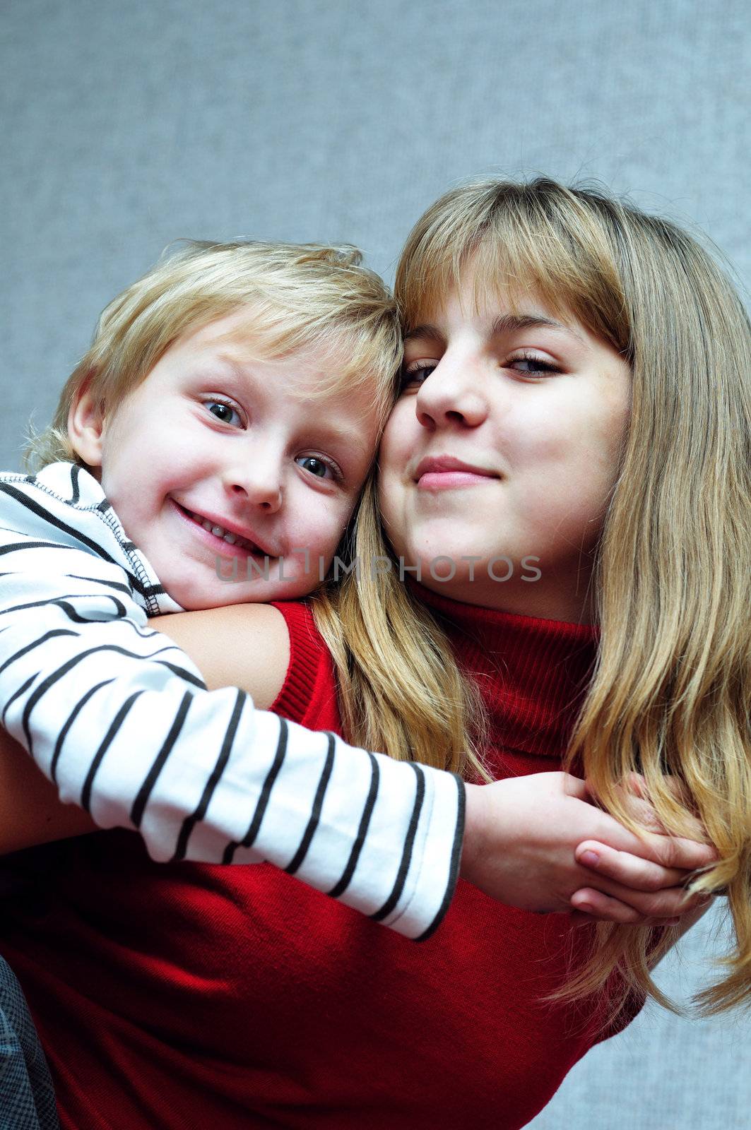 Brother and sister at home smiling and embracing
