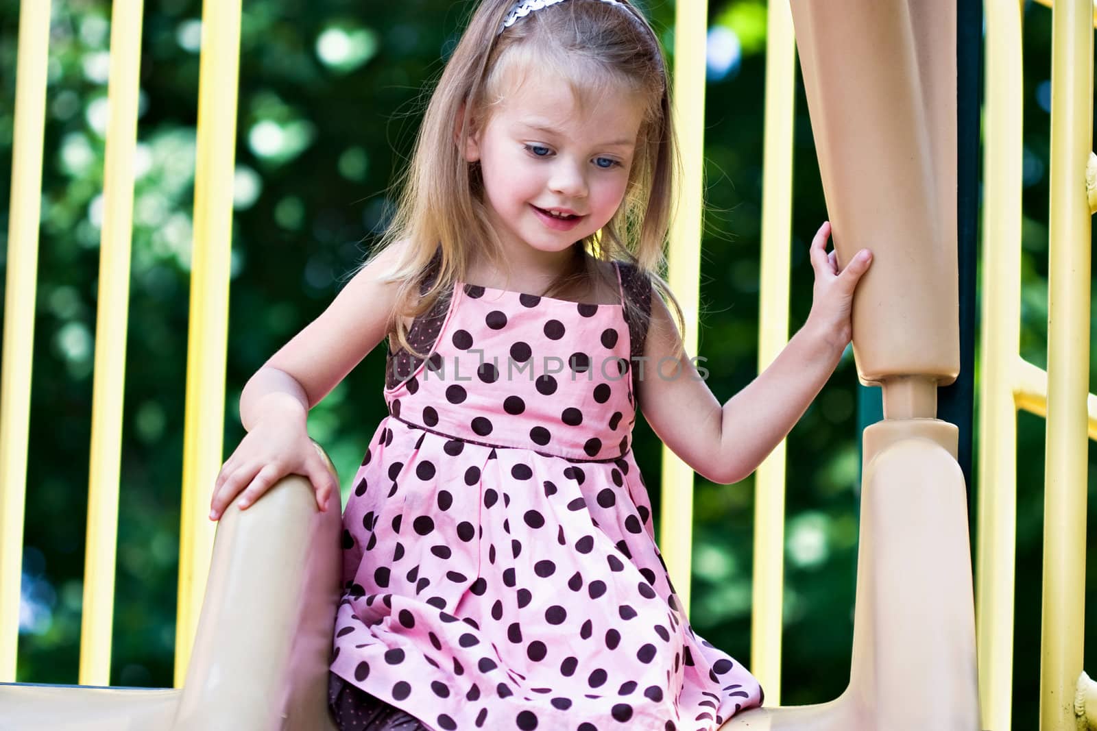 Beautiful little girl playing at the playground.