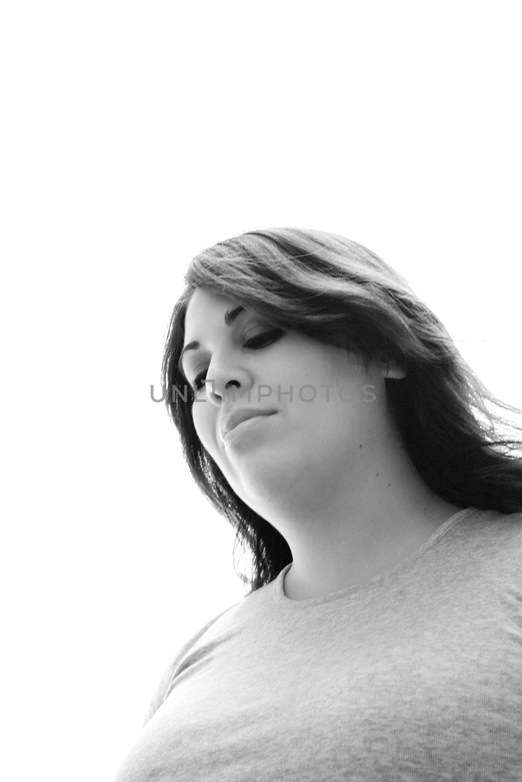 A young woman is thinking about something and looks to be in deep thought.  Plenty of copy space with the girl isolated over white.
