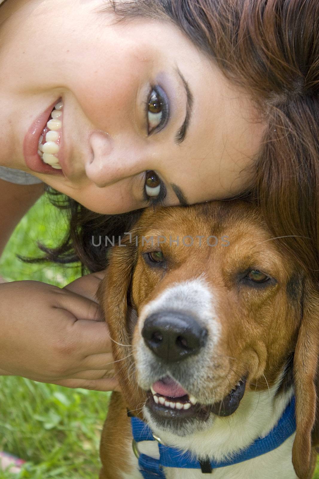 A pretty girl posing with her beagle dog.  Shallow depth of field.