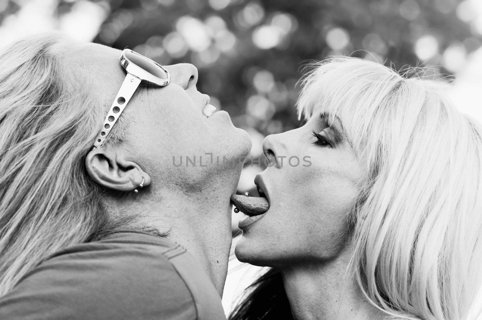 Woman with big eyes licking a man on the neck